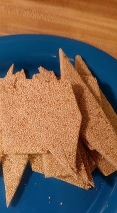 a blue plate topped with crackers on top of a wooden table