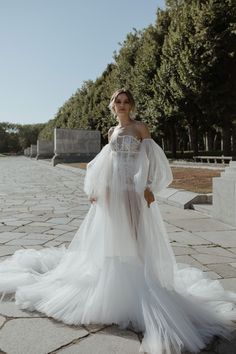 a woman in a white dress standing on the ground