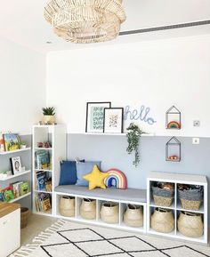 a white and blue playroom with toys, bookshelves, and baskets on the wall