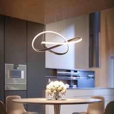 a dining room table with chairs and a light hanging from the ceiling over it's head