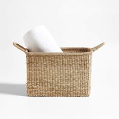 a wicker basket with two white towels in it