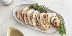 sliced chicken with sauce and herbs on a plate