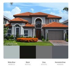 a house with orange tile roofing and white trim on the front, gray garage door