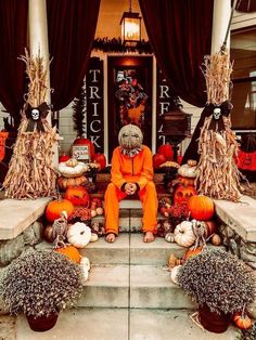 a person in an orange outfit sitting on some steps with pumpkins and corn stalks