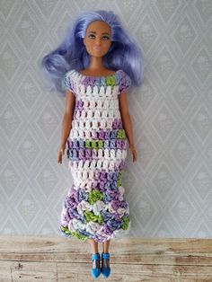 a doll with blue hair is wearing a dress made out of crocheted material