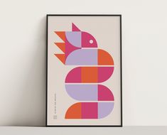 a framed art print with an abstract design in pink, orange and purple on a white wall