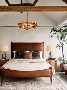 a large bed sitting under a wooden beam next to a plant in a room with white walls