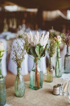 two vases filled with flowers sitting on top of a table