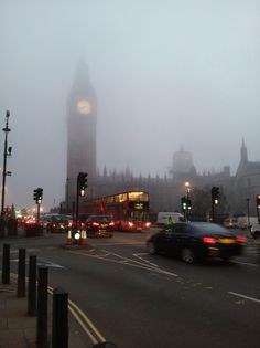 the big ben clock tower towering over the city of london on a foggy day