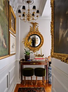 the hallway is decorated with antique furniture and paintings on the walls, along with an ornate console table