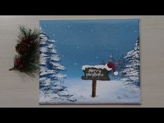 a christmas card with a santa hat on it next to a pine tree and sign