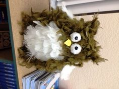 an owl stuffed animal sitting on top of a stack of books