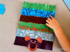 a child's hand on top of a piece of paper that has been made to look like a bear