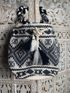 Pile all your necessities in this oversized boho bucket bag. Cream & Black details, 2 pockets inside with a rope drawstring, braided shoulder strap and silver detailing throughout the bag. The perfect bag for vacation or galavanting around town for the day. 50% Cotton 50% Acrylic Made in India Louis Vuitton Gm, Braided Bag, Sachet Bags, Black Bucket, Black And White Flowers, Kate Spade Totes, Pink Purse, Black Leather Tote, Blue Gift