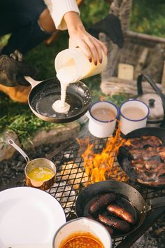 someone is cooking hot dogs over an open fire and grilling them on the grill