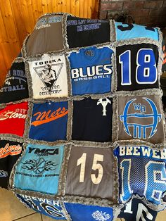 a blanket made out of t - shirts is sitting on the floor