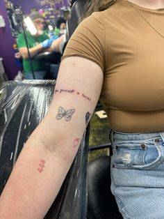 a woman with a butterfly tattoo on her arm in a hairdressers shop