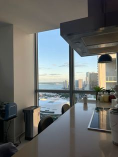 a kitchen with a large window overlooking the ocean and cityscape in the distance