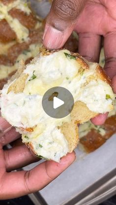 someone is holding up a piece of bread with cheese and spinach spread on it