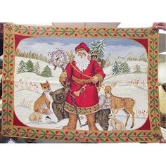 a man holding up a christmas quilt with dogs and santa in the snow behind him