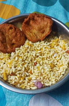 a bowl filled with rice and two fried chicken nuggets next to each other