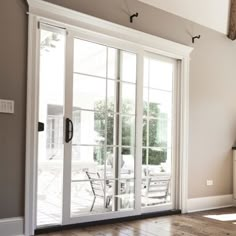 an empty room with sliding glass doors and wood flooring