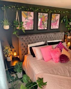 a bedroom decorated in pink and grey with pictures on the wall above the headboard