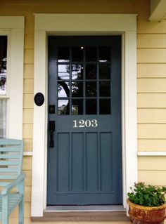 a blue front door with the number 2093 on it and two chairs in front