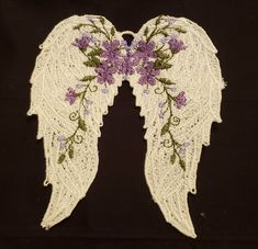 two angel wings with purple flowers on them