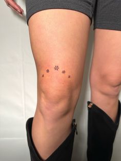 a woman's thigh with small flowers on it and the word love written in black ink