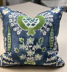 a blue and green pillow sitting on top of a table