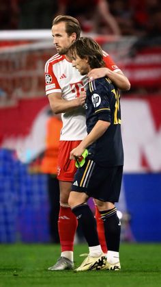 two soccer players embracing each other on the field