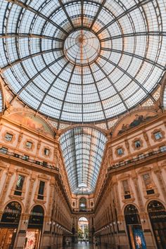 the inside of an indoor shopping mall with glass ceiling and large windows on each side