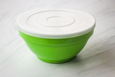 a green and white bowl sitting on top of a counter