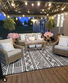 an outdoor patio with wicker furniture and string lights