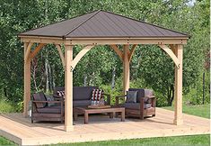 a wooden gazebo sitting on top of a lush green field