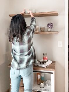 a woman standing in front of a wooden shelf