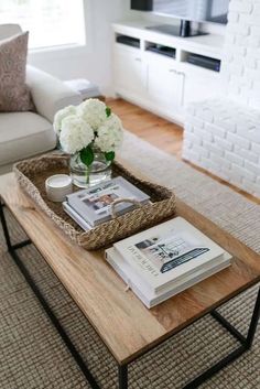 a coffee table with books and flowers on it