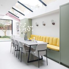 a dining room table with yellow chairs and a bench