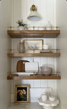 the shelves in this kitchen are filled with dishes and other things to put on them