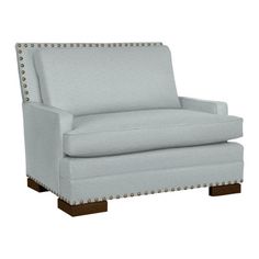 a light blue chair with studding on the armrests and back rests against a white background