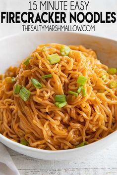 a white bowl filled with noodles and green onions