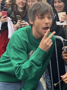 a young man making a funny face in front of a crowd