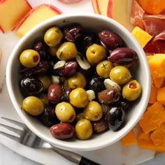 a white bowl filled with olives and cheese