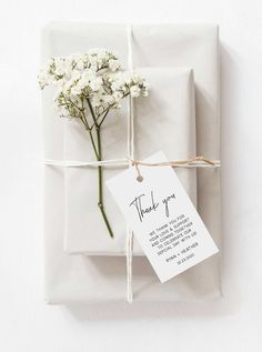 a gift wrapped in white paper and tied with twine, has a tag that says thank you