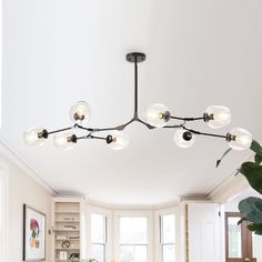 a modern chandelier hangs over a dining room table