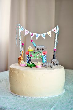 a birthday cake with an elephant and giraffe topper