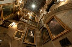 the ceiling is covered in many paintings and frames, including one with a ladder on it