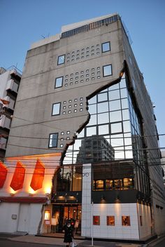 a large building with many windows and people walking by it