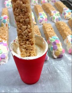 some kind of food that is in a red cup on a table with candy bars